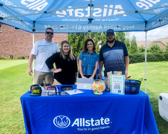 Allstate employees posing under an Allstate tent at Foxland golf course