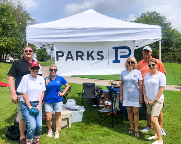 Parks employees posing with their tent at Foxland golf course
